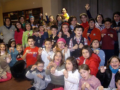 

Los niños muestran sus chapas a la camara junto a las monitoras

