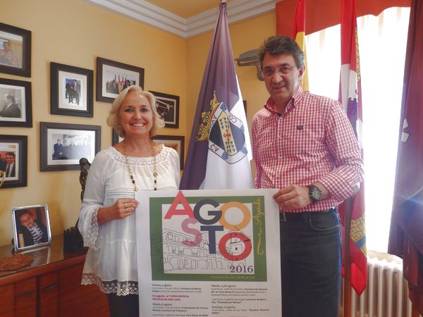 

D. Juan Martínez Majo y Dña. María Jesús Marinelli con el cartel de actividades de Agosto

